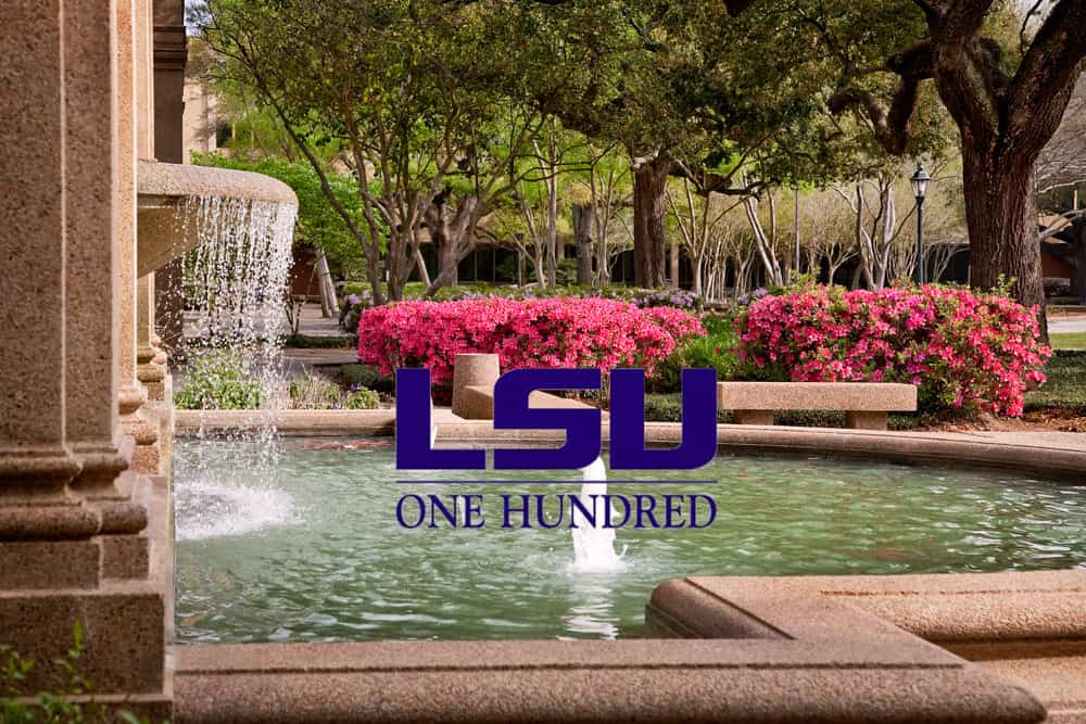 A stone fountain with water flowing, vibrant pink flowers, and trees in the background; LSU One Hundred logo overlaid on the image.